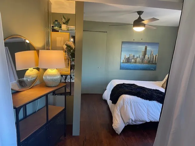 a bedroom with a bed and a lamp on the dresser