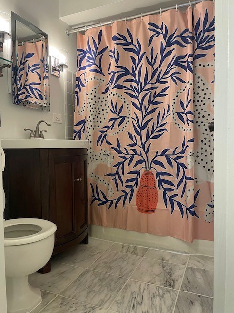 700 West Bittersweet Place, Unit 308 Chicago, IL 60613 - Photo 8 of 11 a bathroom with a toilet and a shower curtain