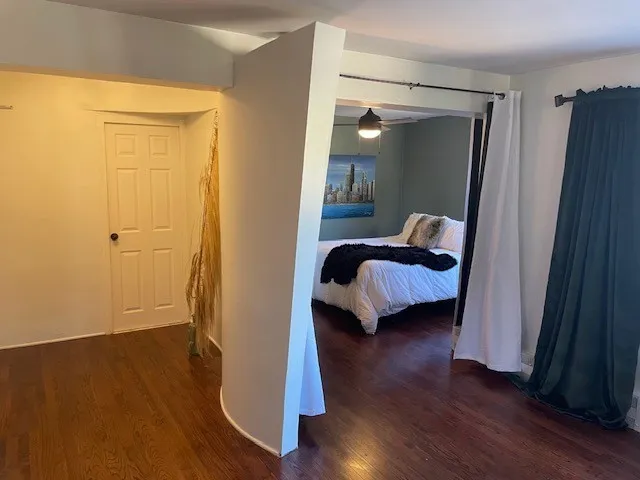 a bedroom with wooden floor and a bed