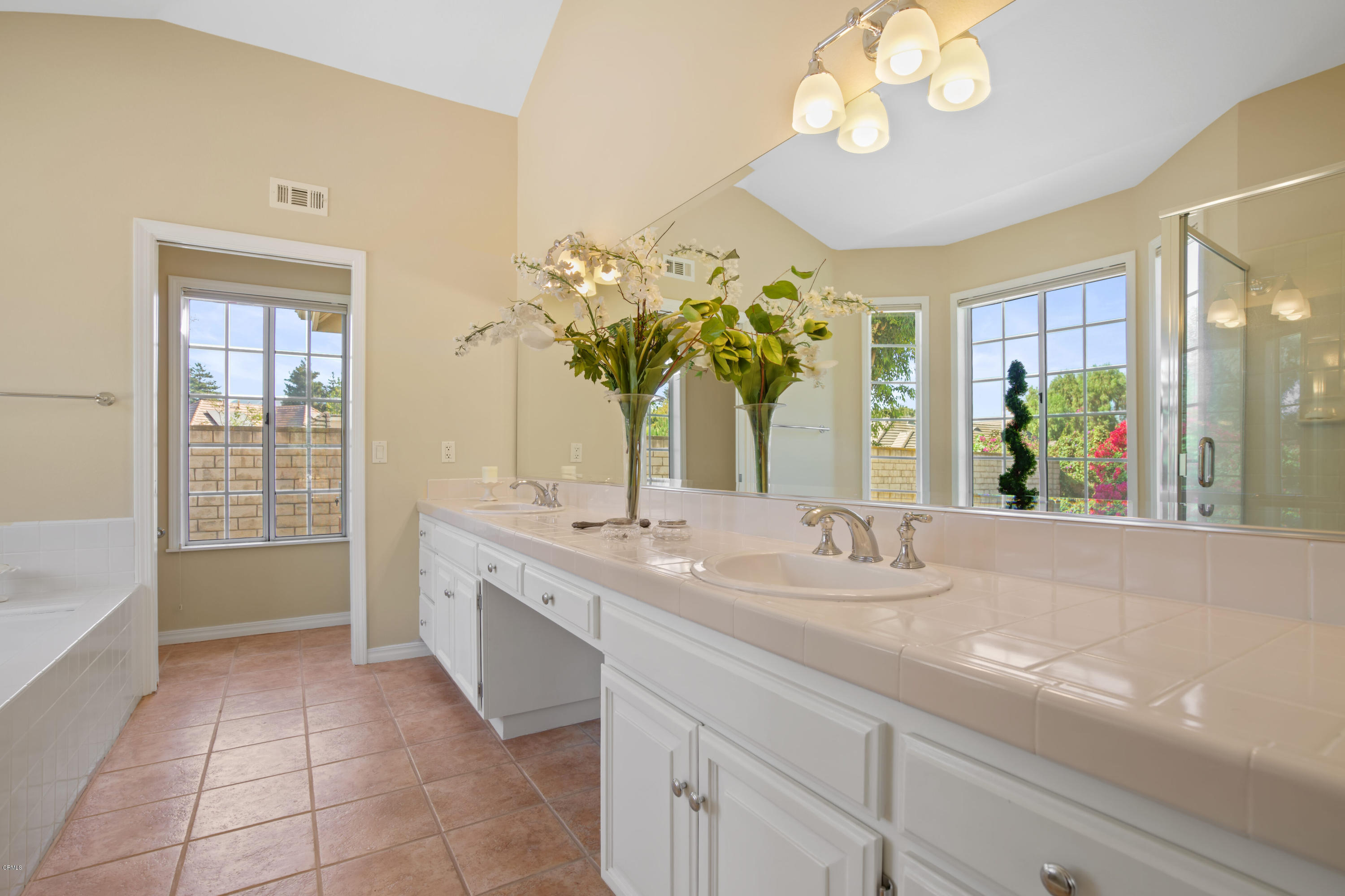 6670 Armitos Drive Camarillo, CA 93012 - Photo 20 of 35 a spacious bathroom with a granite countertop sink a large mirror and a bathtub