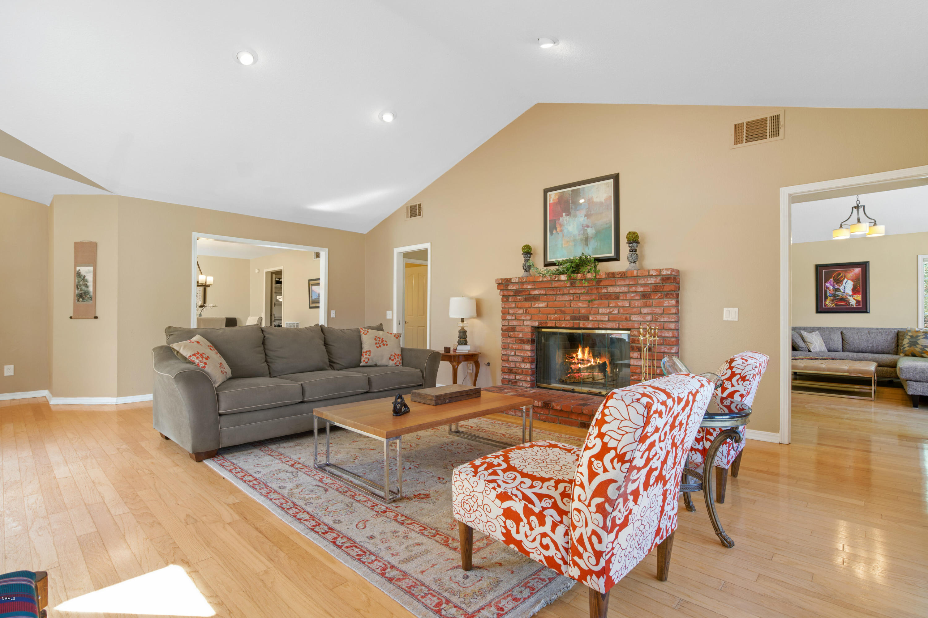 6670 Armitos Drive Camarillo, CA 93012 - Photo 6 of 35 a living room with furniture a fireplace and a dining table with wooden floor