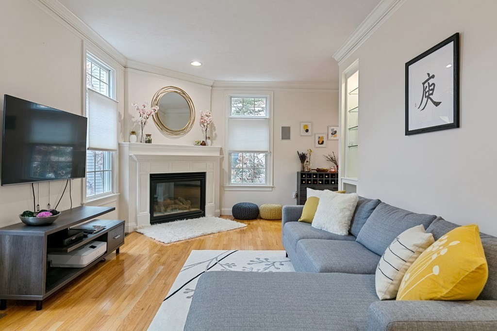 9 Chestnut Lane, Unit 9 Lexington, MA 02421 - Photo 8 of 32 a living room with furniture a flat screen tv and a fireplace