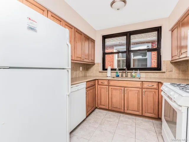 a kitchen with stainless steel appliances granite countertop a sink and a refrigerator