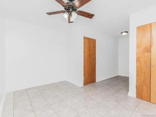 an empty room with a ceiling fan and a window
