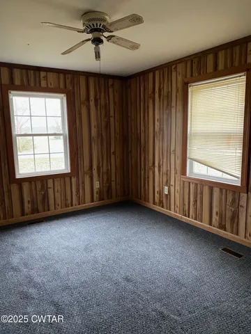 a view of a livingroom with a ceiling fan and window