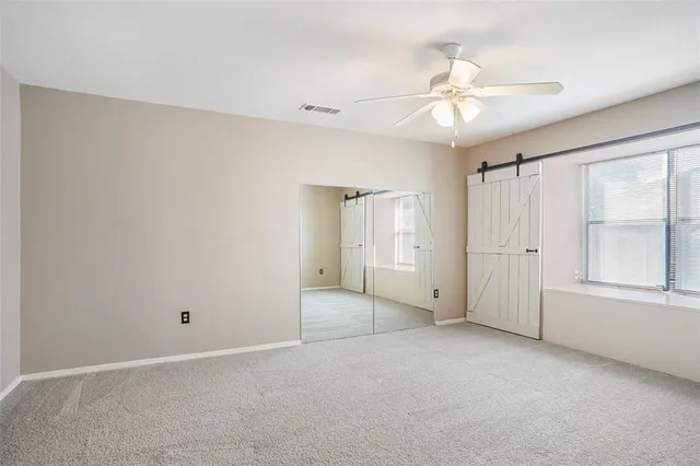 a room with a ceiling fan and a window