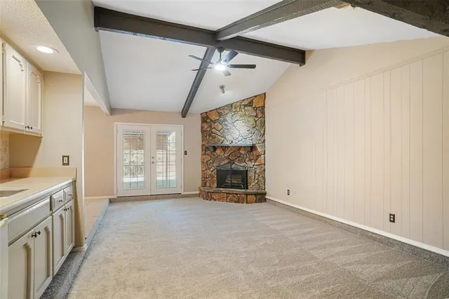 a view of an empty room with a fireplace and a window