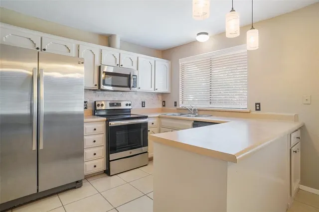 a kitchen with white cabinets and sink