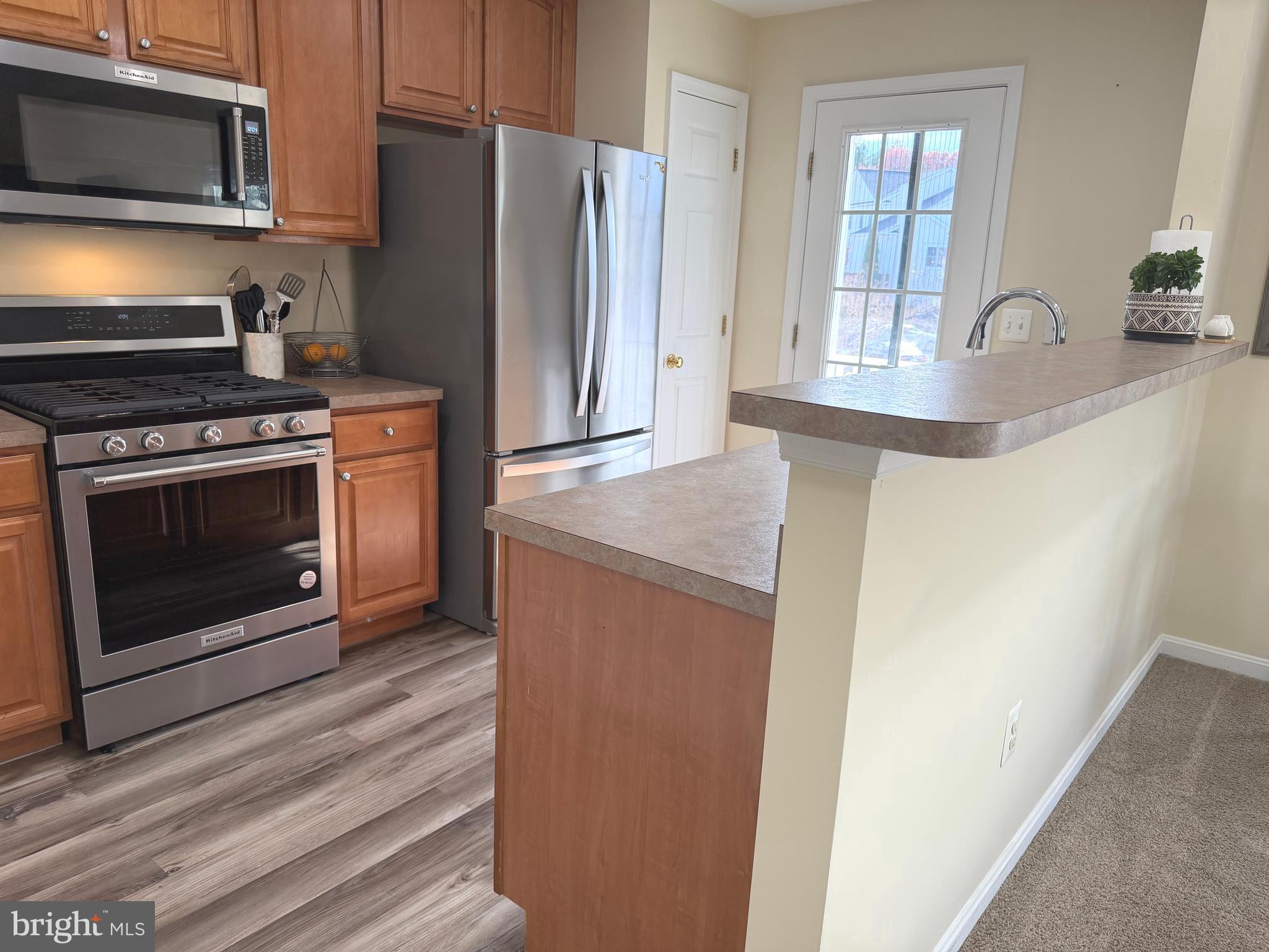 2013 Astilbe Way, Unit 2013 Odenton, MD 21113 - Photo 4 of 61 a kitchen with stainless steel appliances granite countertop a refrigerator a stove a sink and a microwave