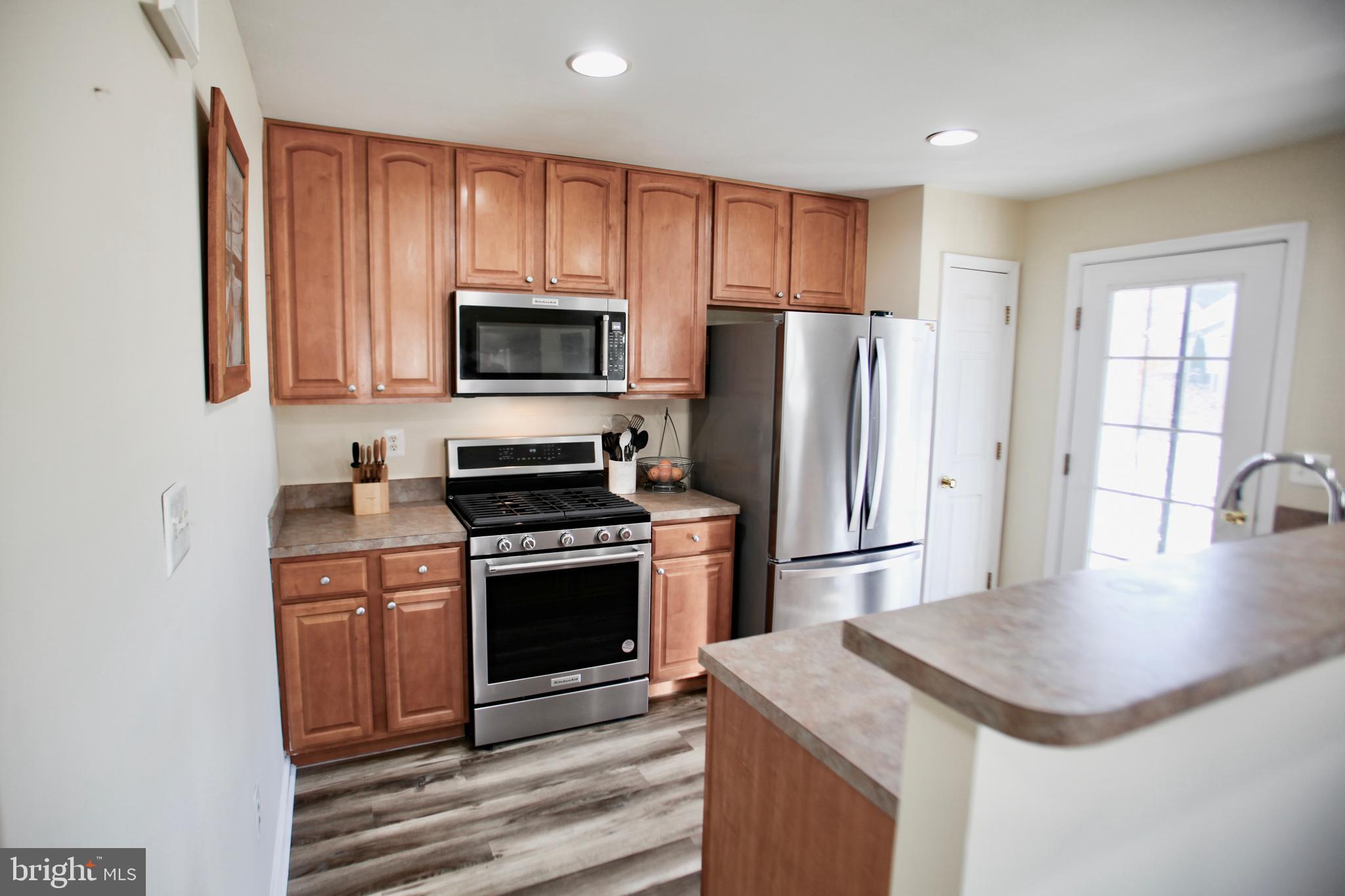 2013 Astilbe Way, Unit 2013 Odenton, MD 21113 - Photo 5 of 61 a kitchen with kitchen island a stove a sink and a refrigerator