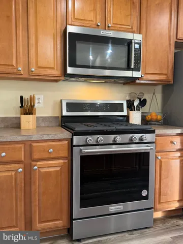 a view of a refrigerator in kitchen and an empty room