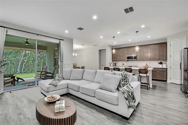 a living room with furniture a flat screen tv and a large window