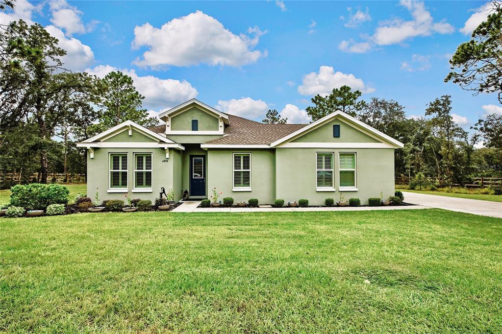 6098 North Peardale Terrace Beverly Hills, FL 34465 - Photo 2 of 59 a front view of a house with a garden