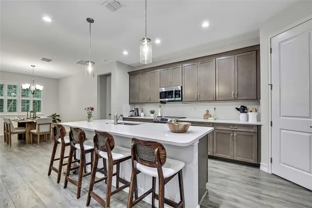 a kitchen with lots of wooden furniture appliances and cabinets