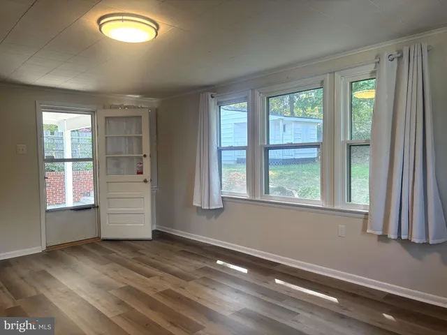 an empty room with windows & cabinet
