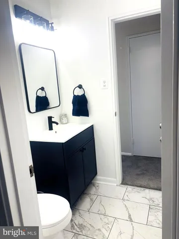 a bathroom with a toilet a sink a vanity and mirror