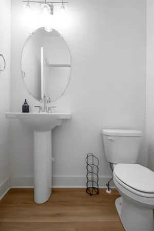 a bathroom with a toilet a sink and mirror