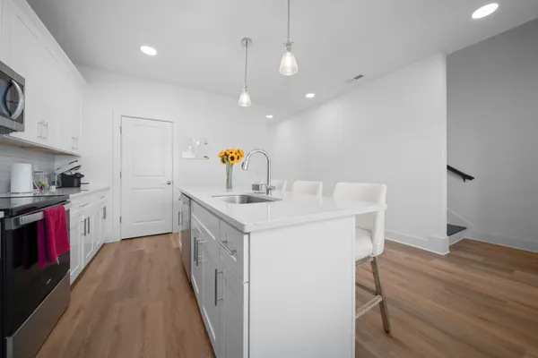 a kitchen with kitchen island a stove a sink and a refrigerator