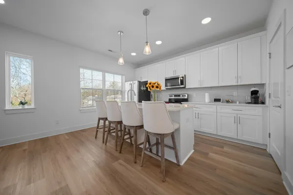 a kitchen with kitchen island granite countertop a sink cabinets and wooden floor