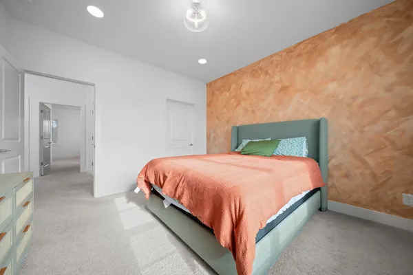 a bed sitting in a bedroom next to a bathroom