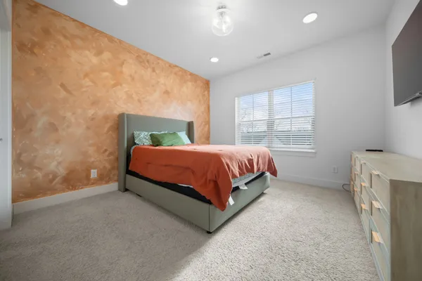 a bedroom with a bed and a flat screen tv