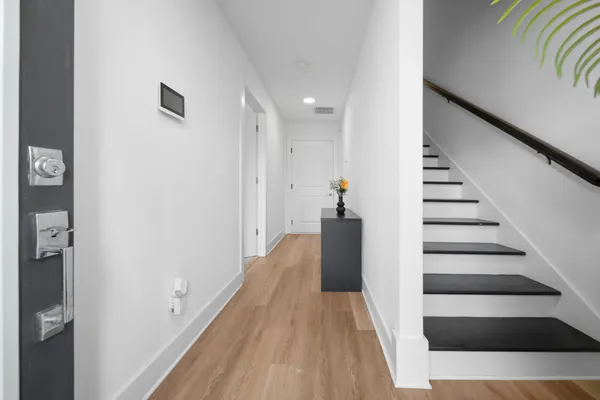 a view of a hallway with wooden floor and staircase