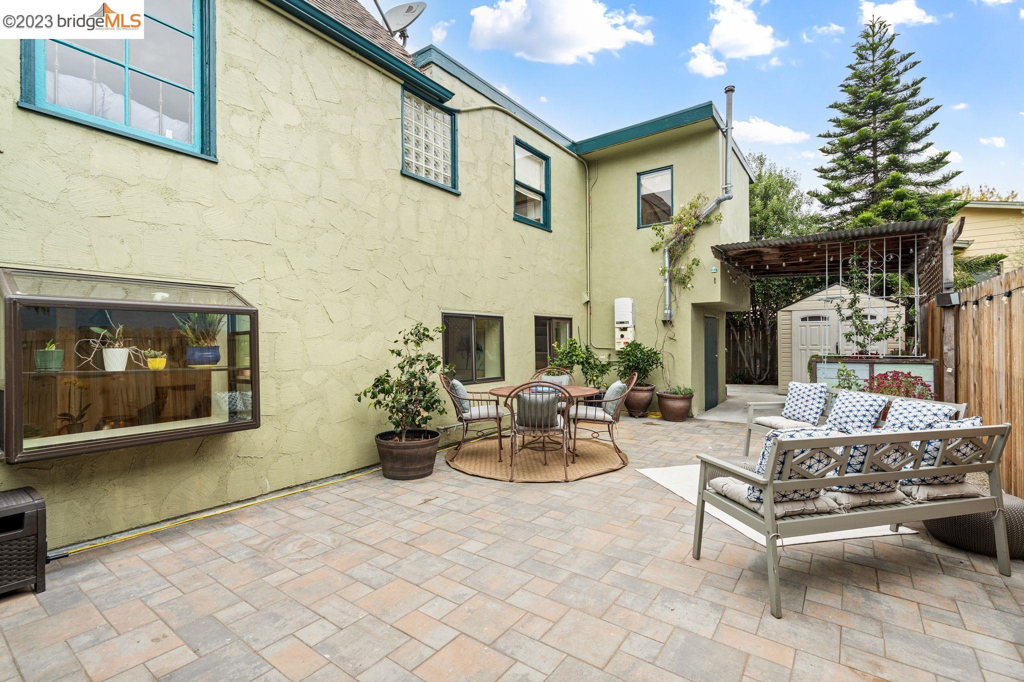 a view of a patio with couches table and chairs under an umbrella