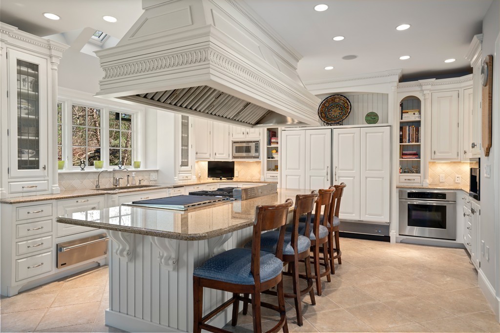 49 Possum Road Weston, MA 02493 - Photo 8 of 33 a kitchen with stainless steel appliances kitchen island granite countertop a table and chairs