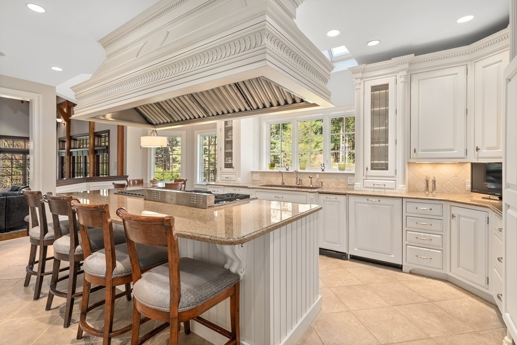 49 Possum Road Weston, MA 02493 - Photo 9 of 33 a kitchen with cabinets a sink dishwasher a dining table and chairs with wooden floor