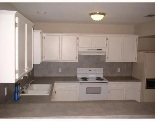 a kitchen with cabinets appliances and a counter space