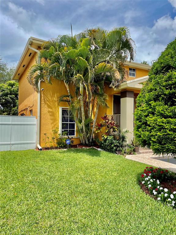 5871 Woodland Point Drive Tamarac, FL 33319 - Photo 1 of 10 a front view of a house with a garden