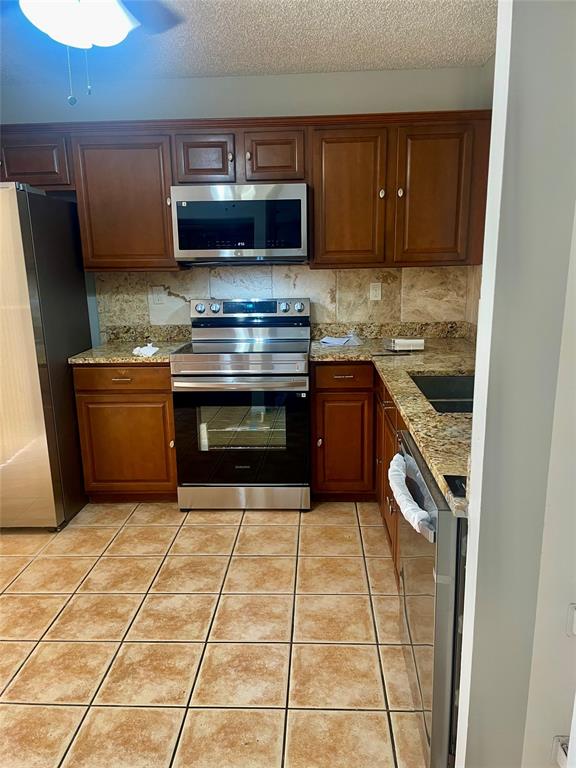 5871 Woodland Point Drive Tamarac, FL 33319 - Photo 7 of 10 a kitchen with stainless steel appliances granite countertop a stove a sink and a microwave