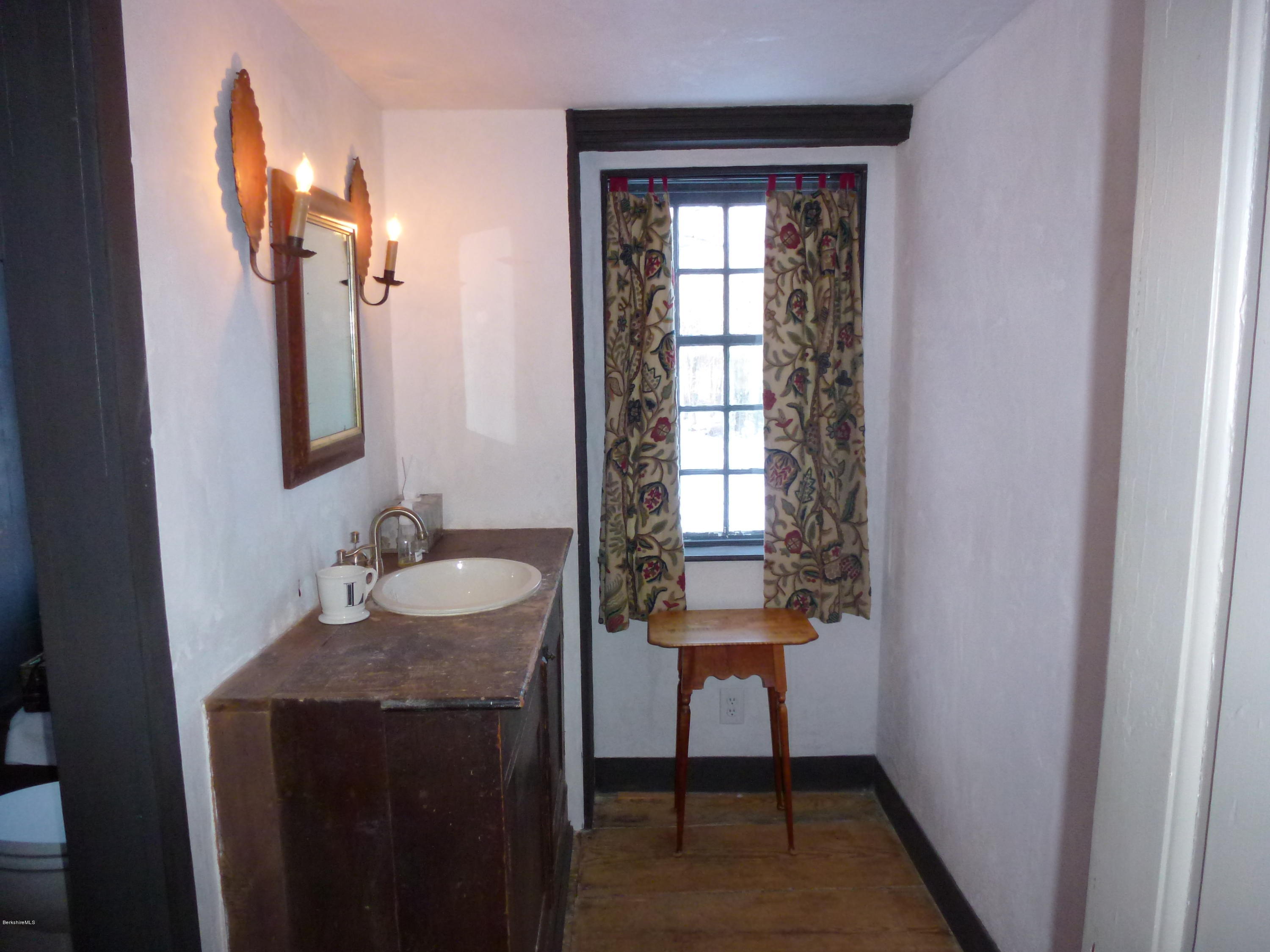 1600 Russell Road Montgomery, MA 01085 - Photo 19 of 36 a bathroom with a granite countertop sink a mirror and a window