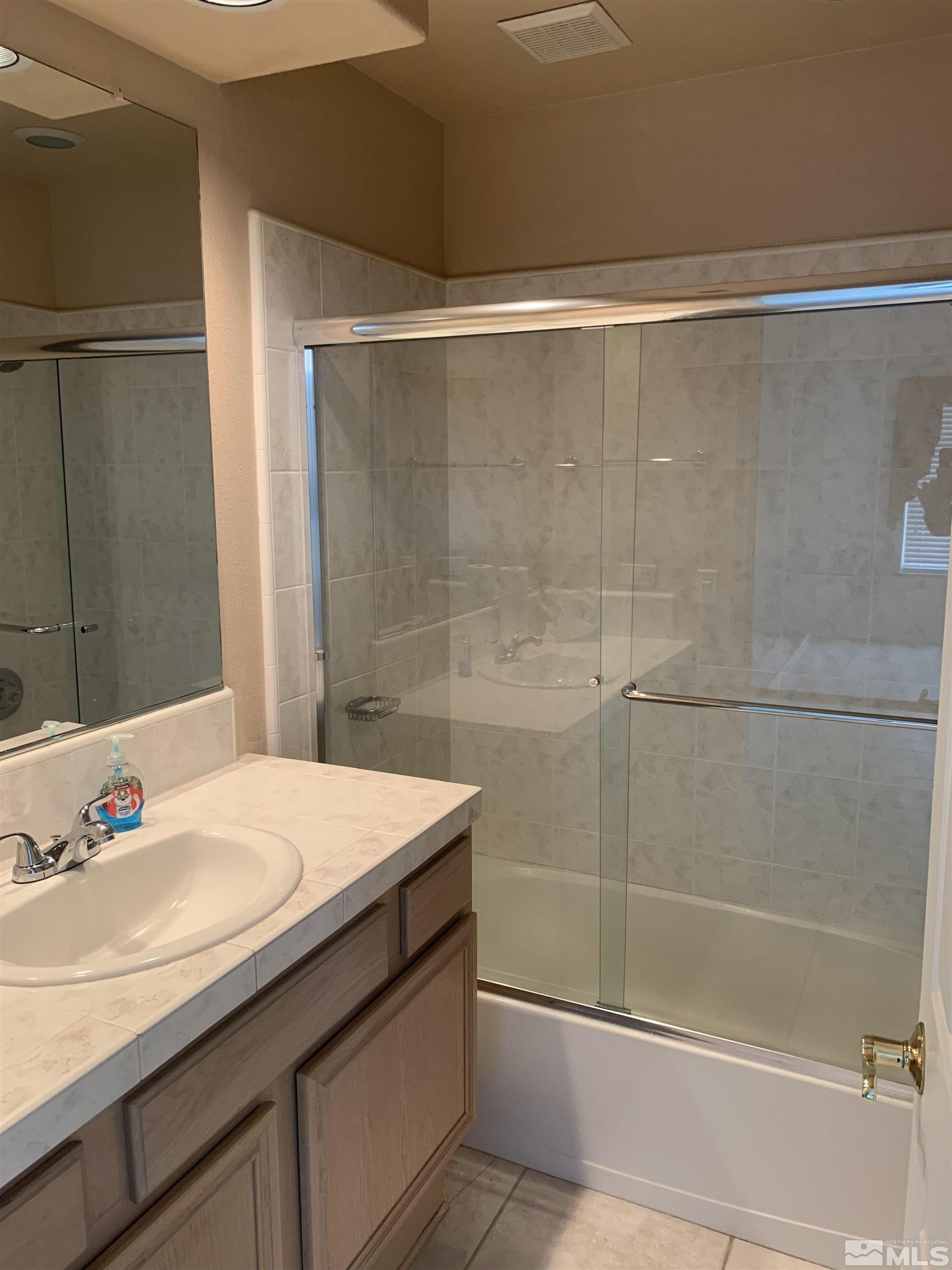 1124 University Ridge Drive Reno, NV 89512 - Photo 10 of 24 a bathroom with a granite countertop sink and a mirror