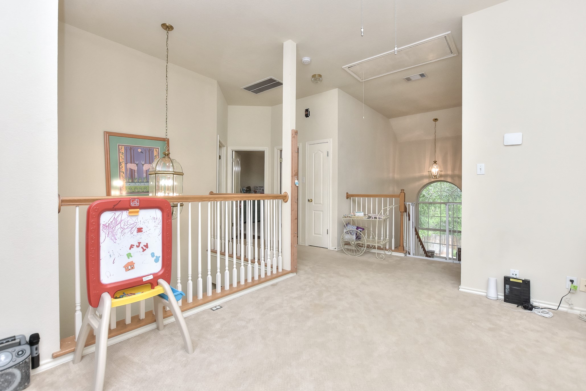 1609 Colton Way Cedar Park, TX 78613 - Photo 11 of 24 A versatile upstairs loft with carpeted floors and a white wooden railing provides an airy transition between living spaces.
