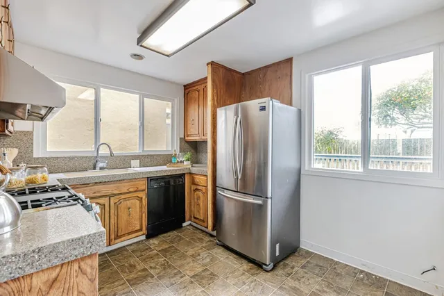 a kitchen with stainless steel appliances granite countertop a refrigerator and a sink