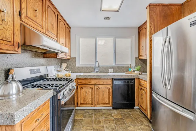a kitchen with stainless steel appliances granite countertop a sink stove and refrigerator