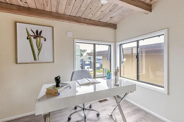 a view of a workspace with furniture and a window