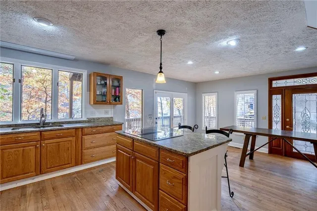 a kitchen with center island with sink and wooden floor