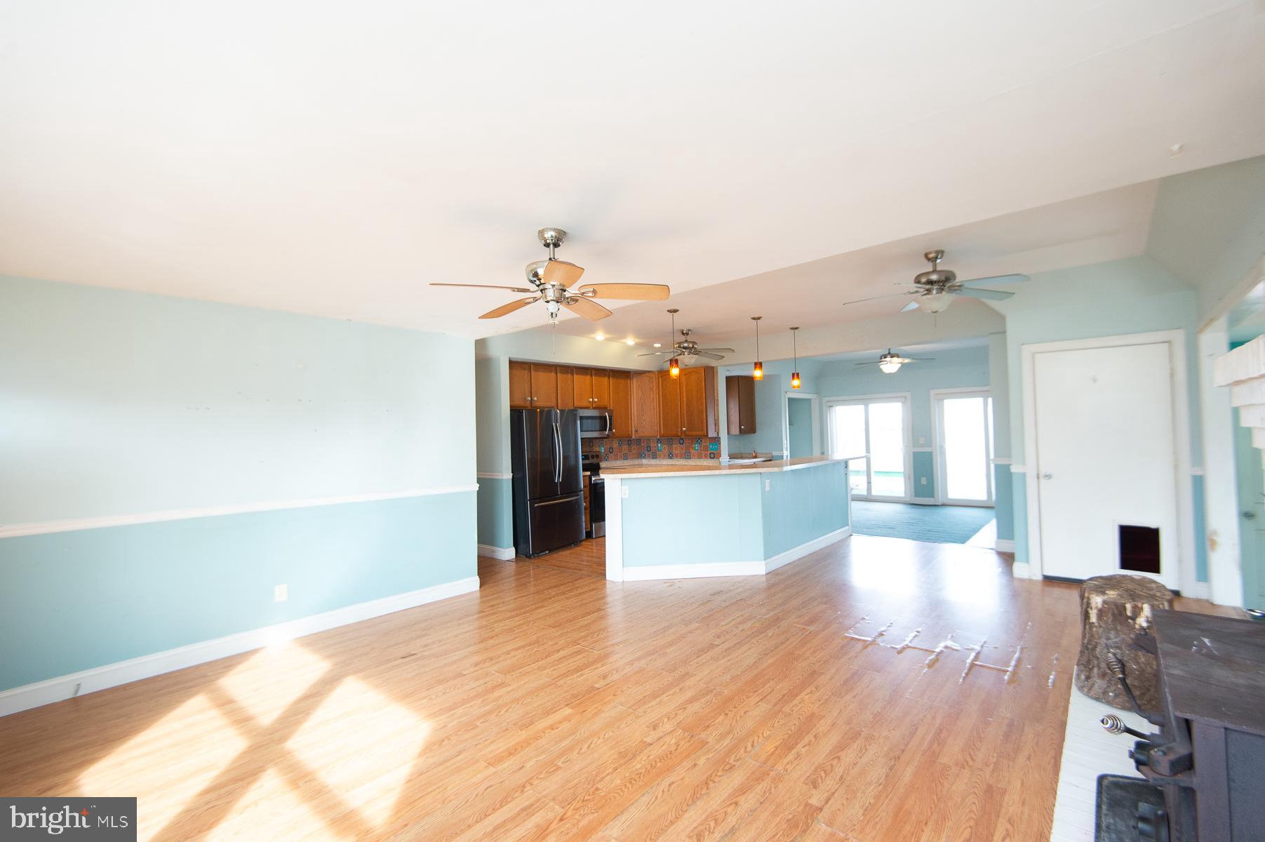 1210 Stone Boundary Road Cambridge, MD 21613 - Photo 12 of 63 a view of a kitchen with kitchen island a sink wooden floor and a living room