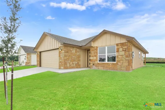 a view of a house with a yard and sitting area