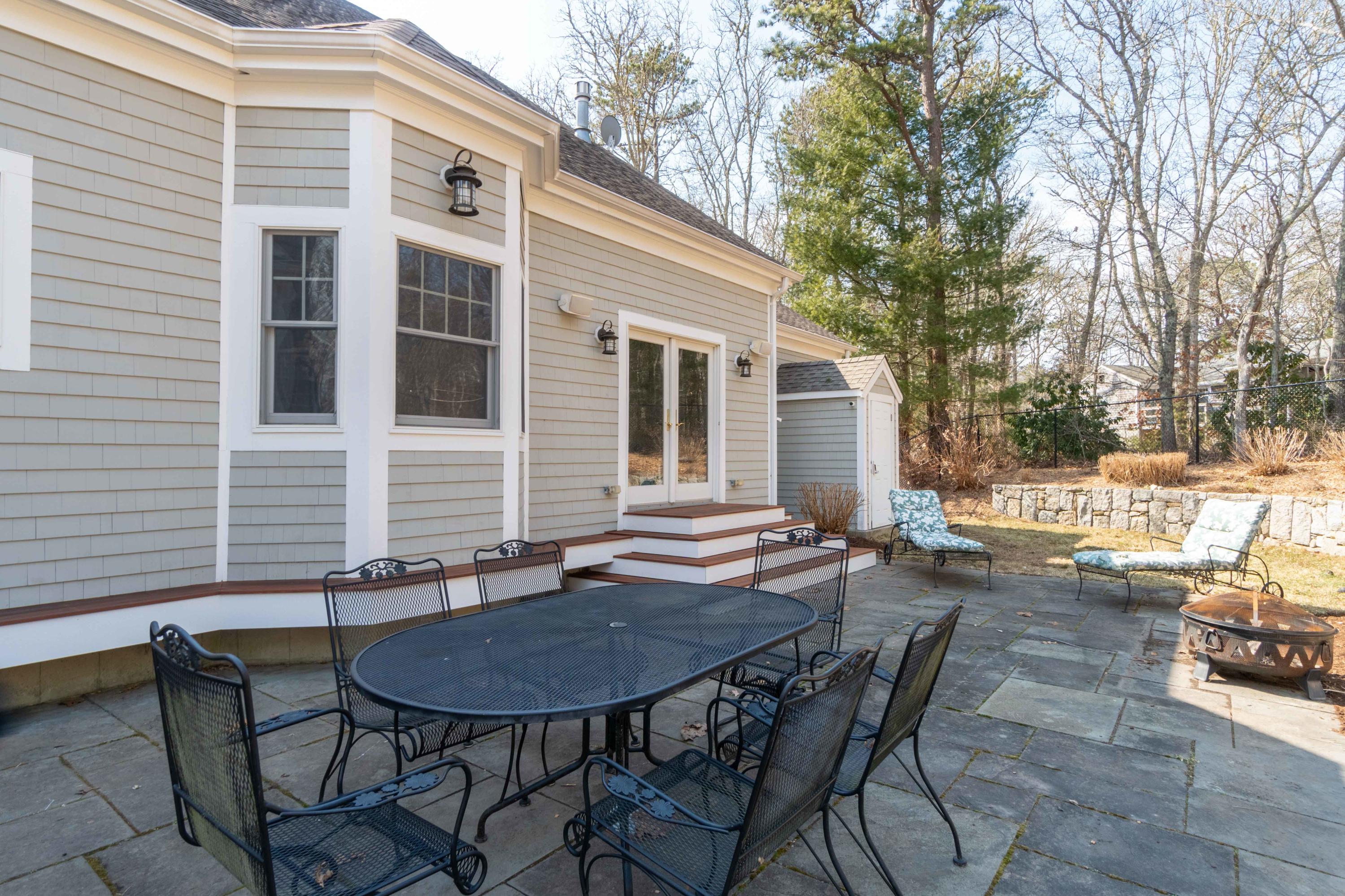 5 Pasture Road Cataumet, MA 02534 - Photo 35 of 52 a backyard of a house with table and chairs