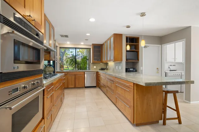 a kitchen with stainless steel appliances kitchen island granite countertop a stove a sink and a microwave