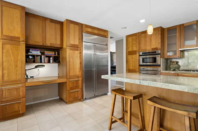 a kitchen with stainless steel appliances granite countertop a refrigerator and a stove top oven
