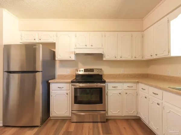 a kitchen with granite countertop white cabinets and white appliances