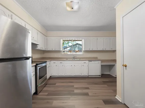 a kitchen with a refrigerator stove and white cabinets