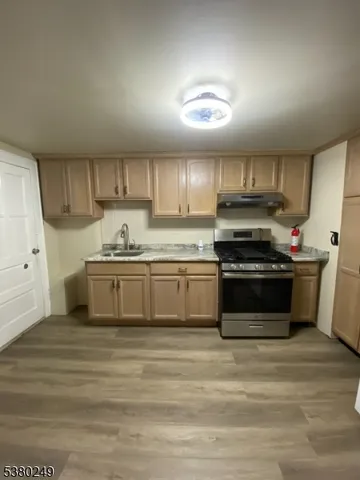 a kitchen with stainless steel appliances a stove a sink and white cabinets