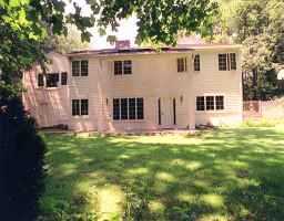 a view of a yard in front of a house with plants and trees