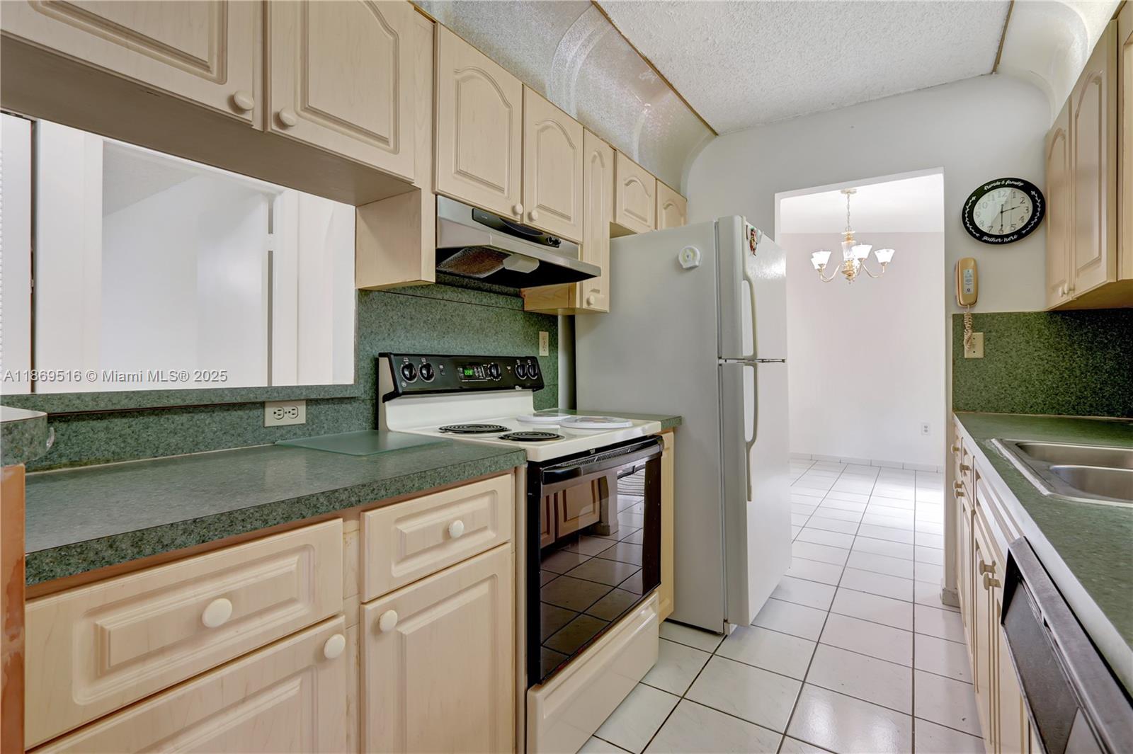 8133 Southwest 152nd Court Miami, FL 33193 - Photo 13 of 20 a kitchen with granite countertop a sink a stove and cabinets