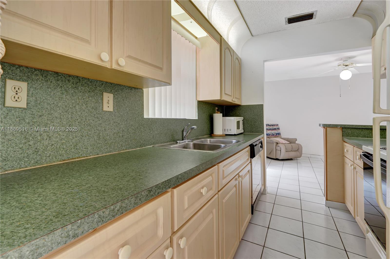 8133 Southwest 152nd Court Miami, FL 33193 - Photo 14 of 20 a kitchen with a sink cabinets and a wooden floor